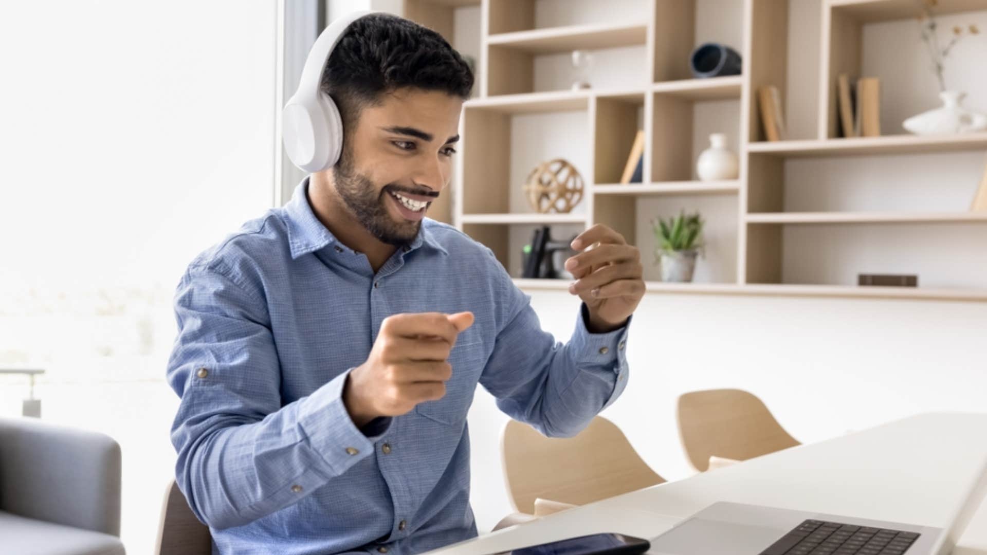 man wearing headphones watching his laptop