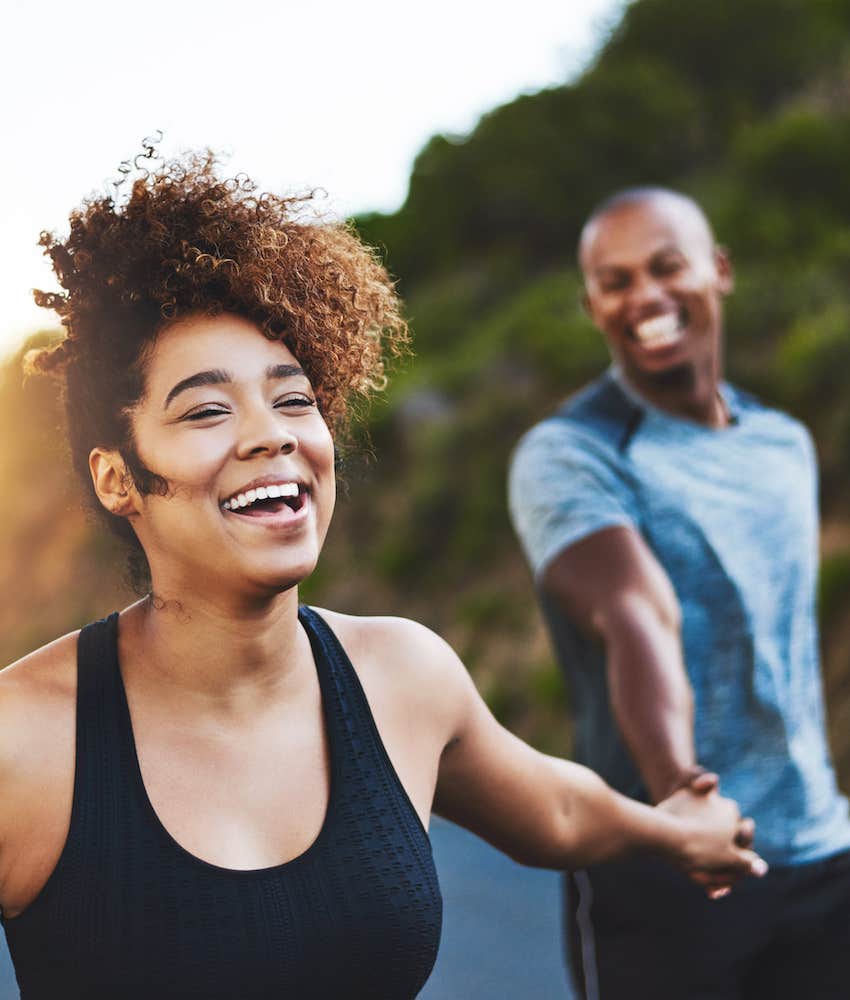 Couple walks hand in hand while laughing