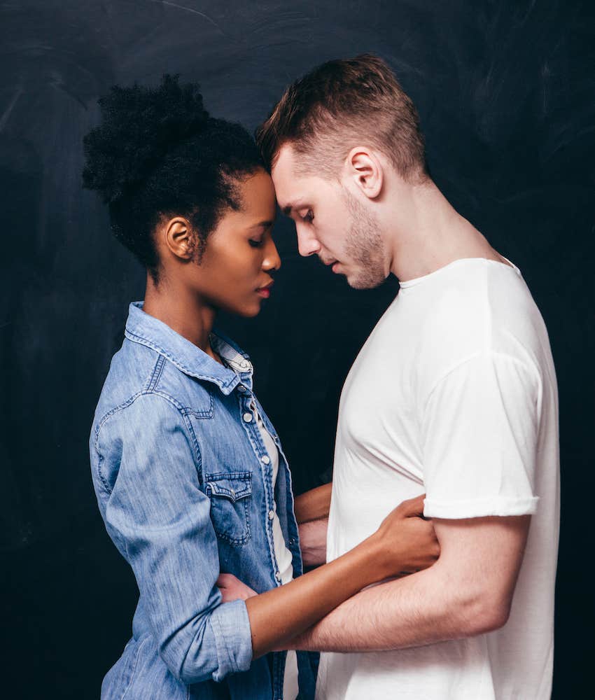 Couple stands calmly forehead to forehead