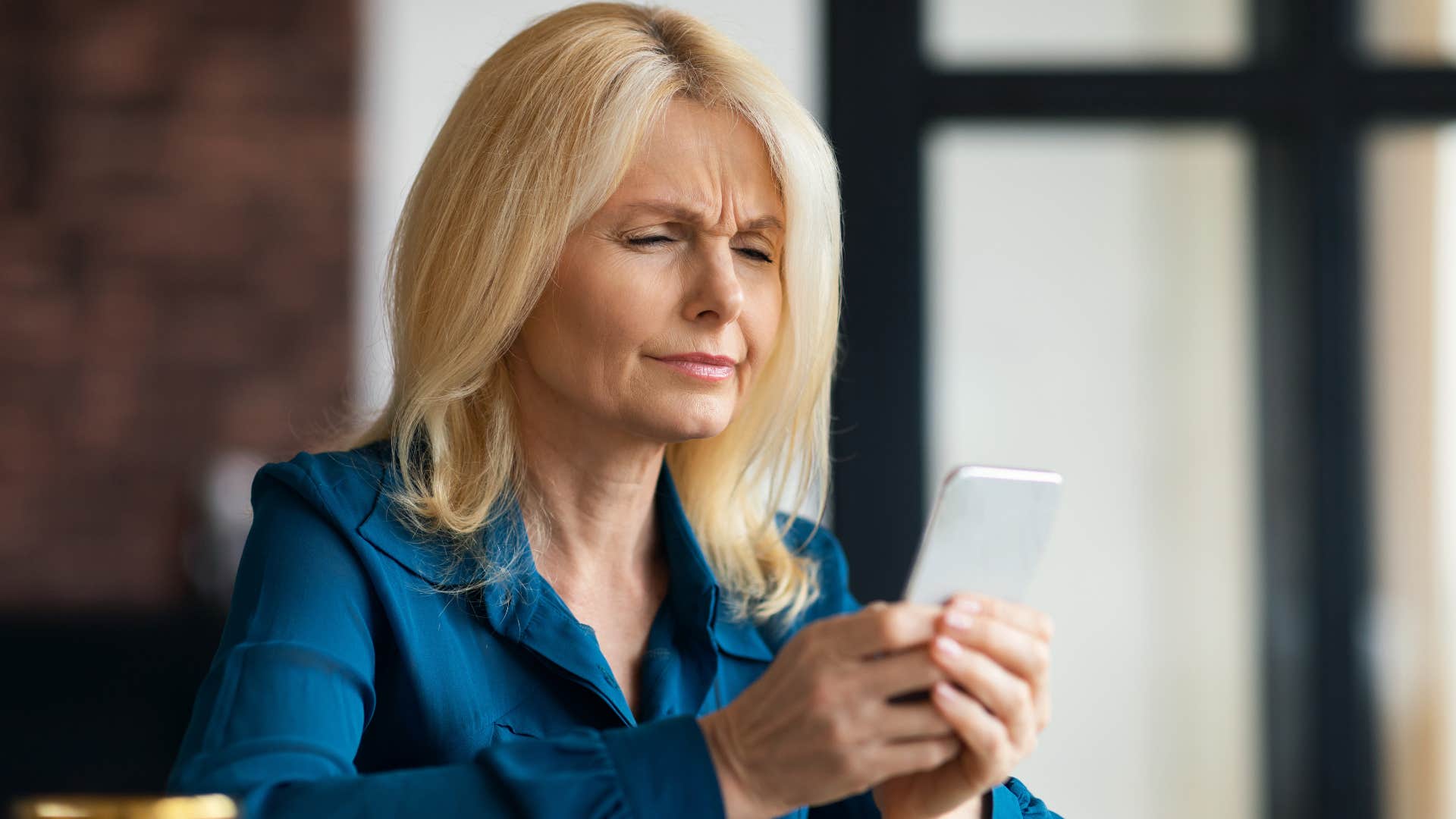 Woman suspicious of news on her phone because she knows the critical fact that propaganda works on everyone