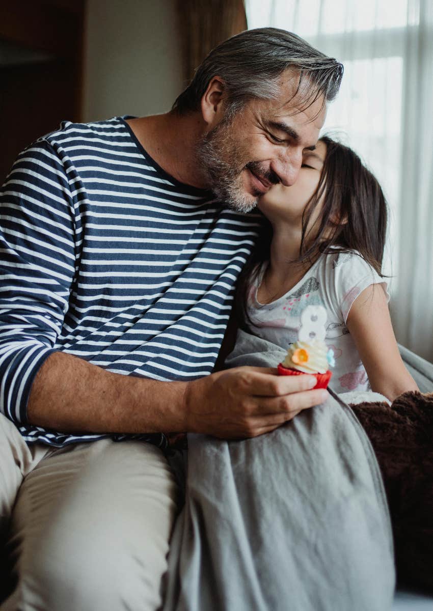 dad and daughter celebrating birthday with cupcake