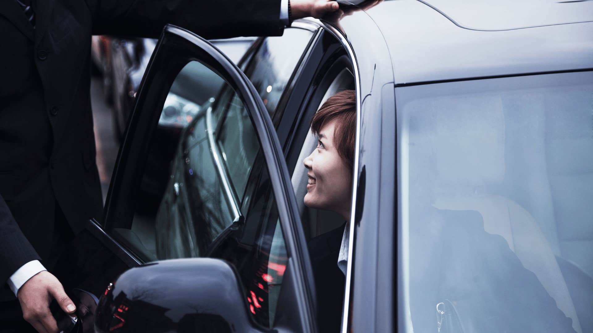 man holding car door open for woman