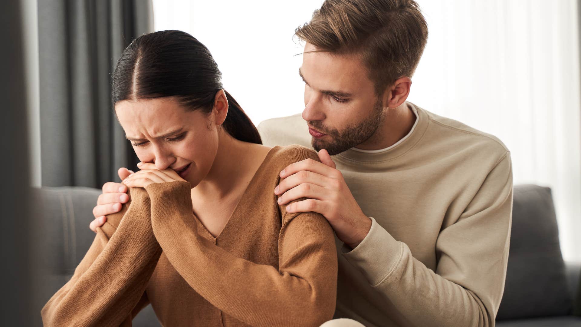 emotional woman crying while being comforted