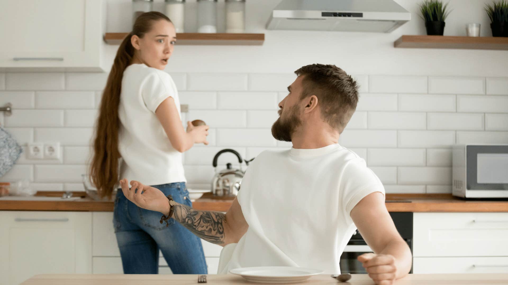 man nagging his wife in kitchen