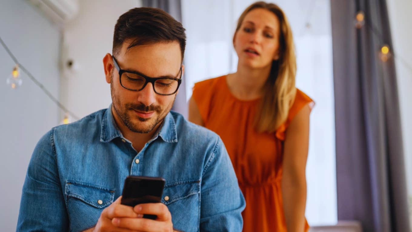 woman looking at husband cheating