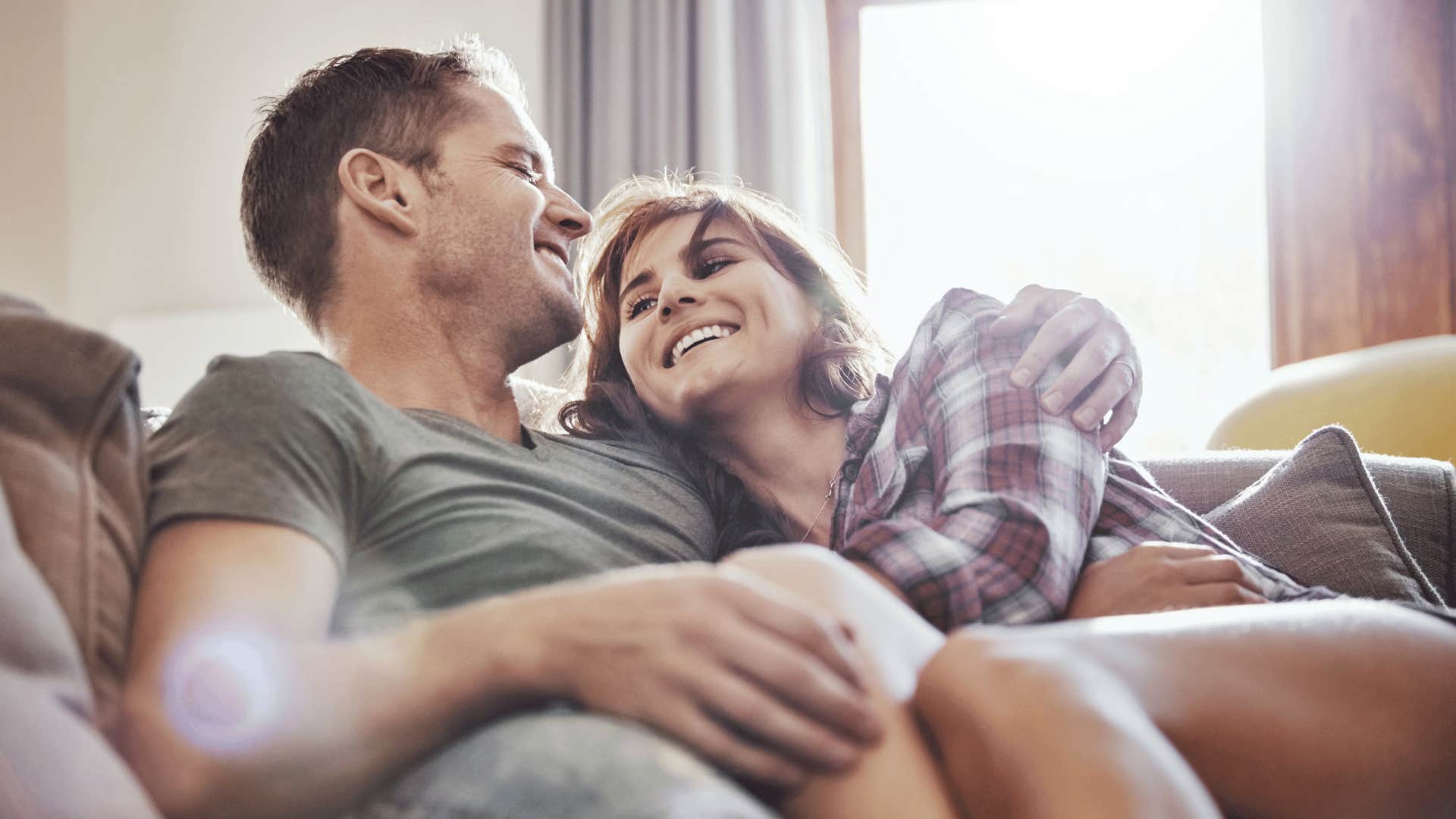 happy couple cuddling on couch