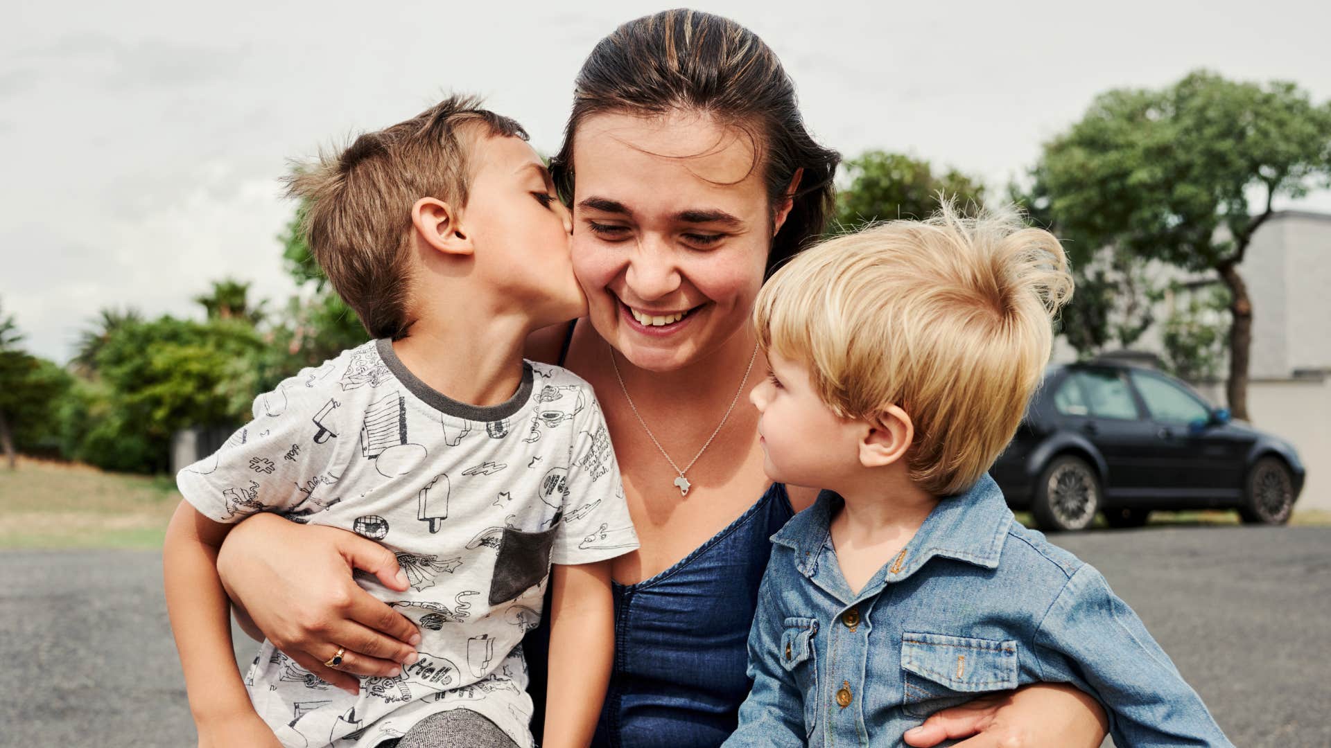 Shot of a beautiful young mother having fun with her little boys outdoors