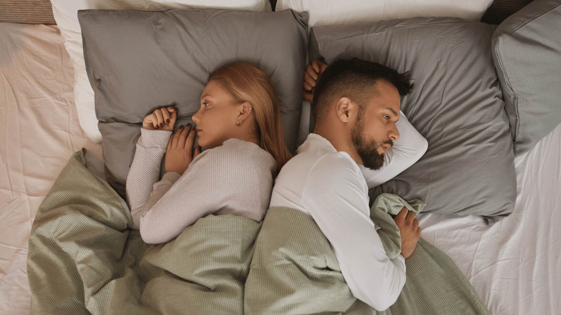 upset couple sleeping in bed