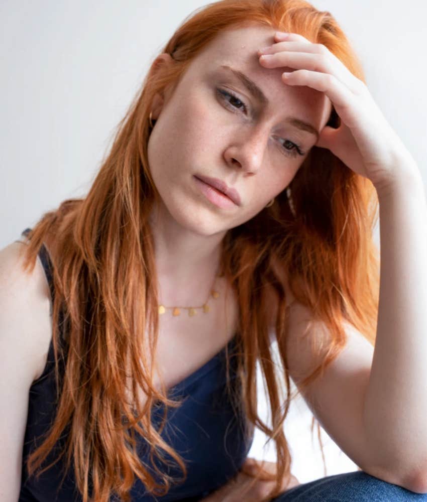 Redhaired woman sad because partner gave bad excuse for cheating