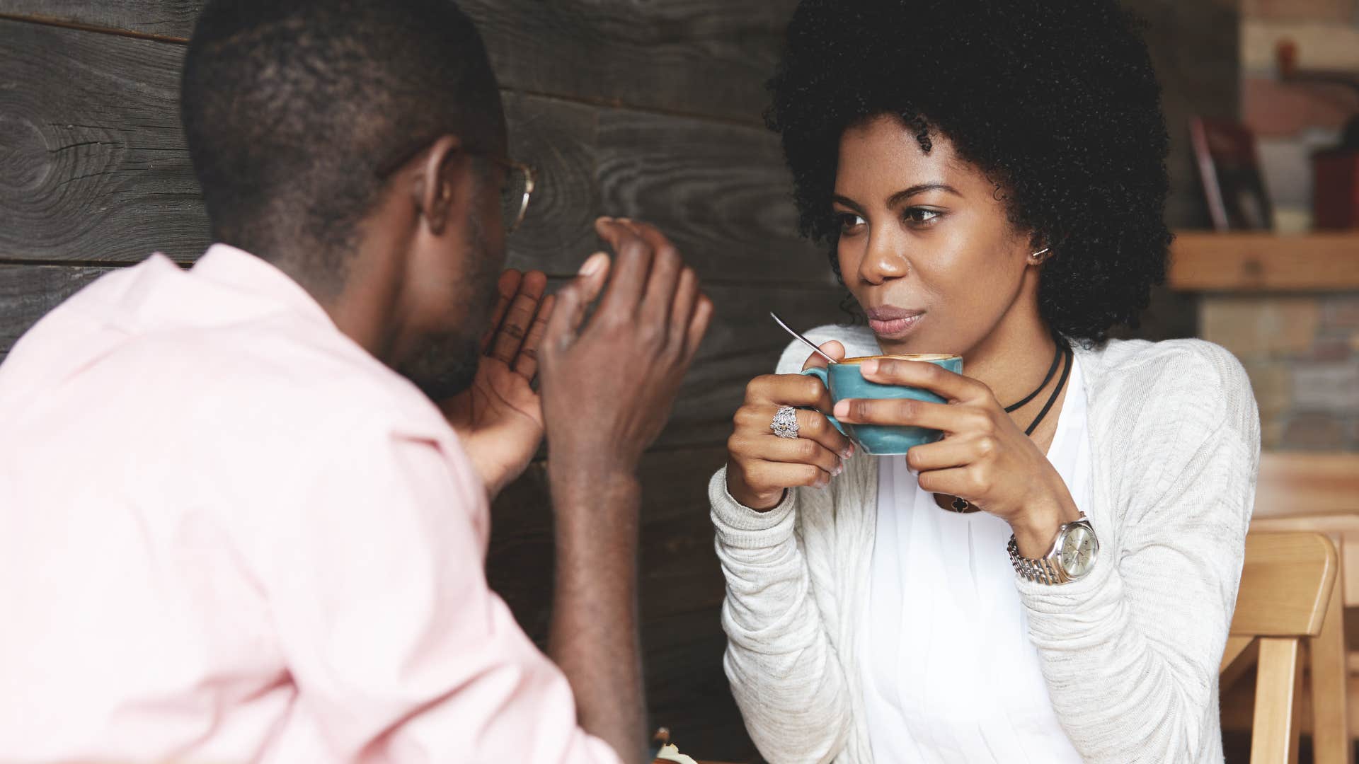 couple smiling and drinking coffee in public