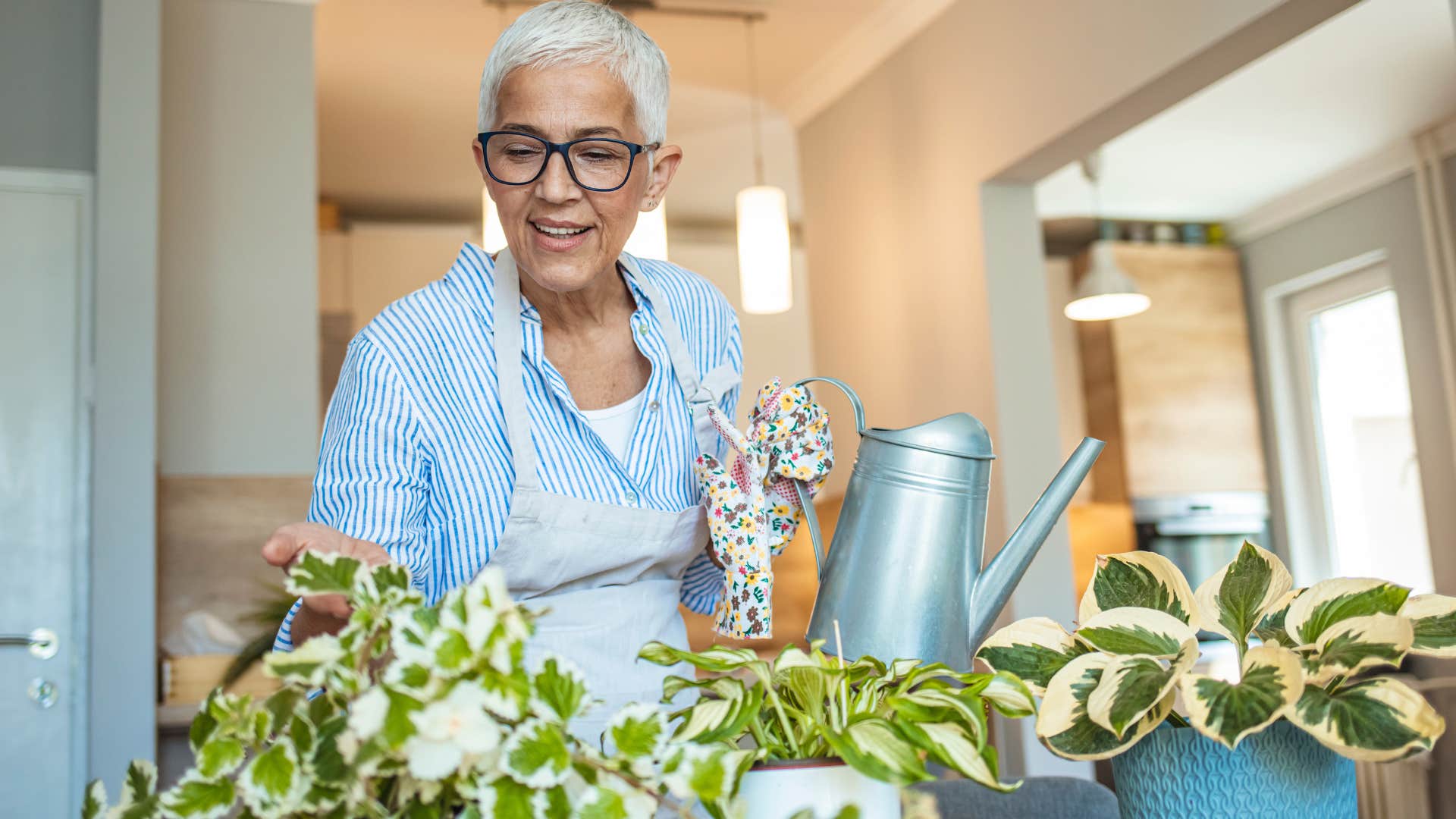 woman watering her plants inside