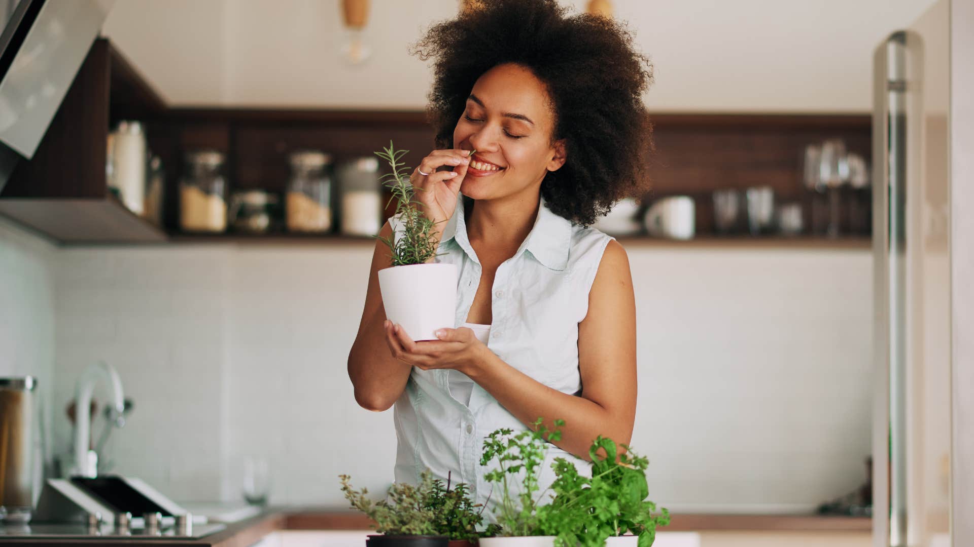 woman smelling herbs in her kitchen