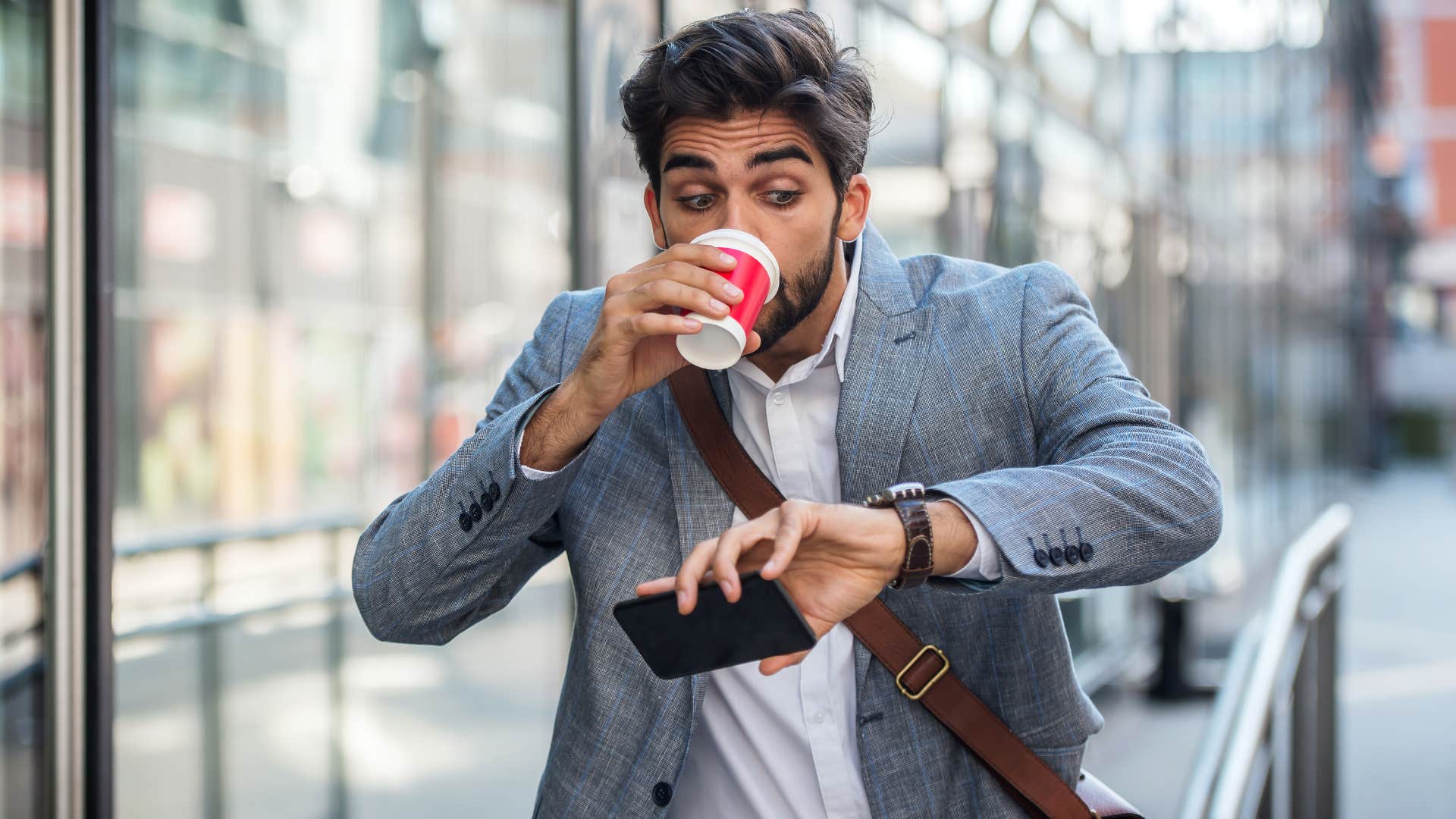 young man running late while drinking coffee