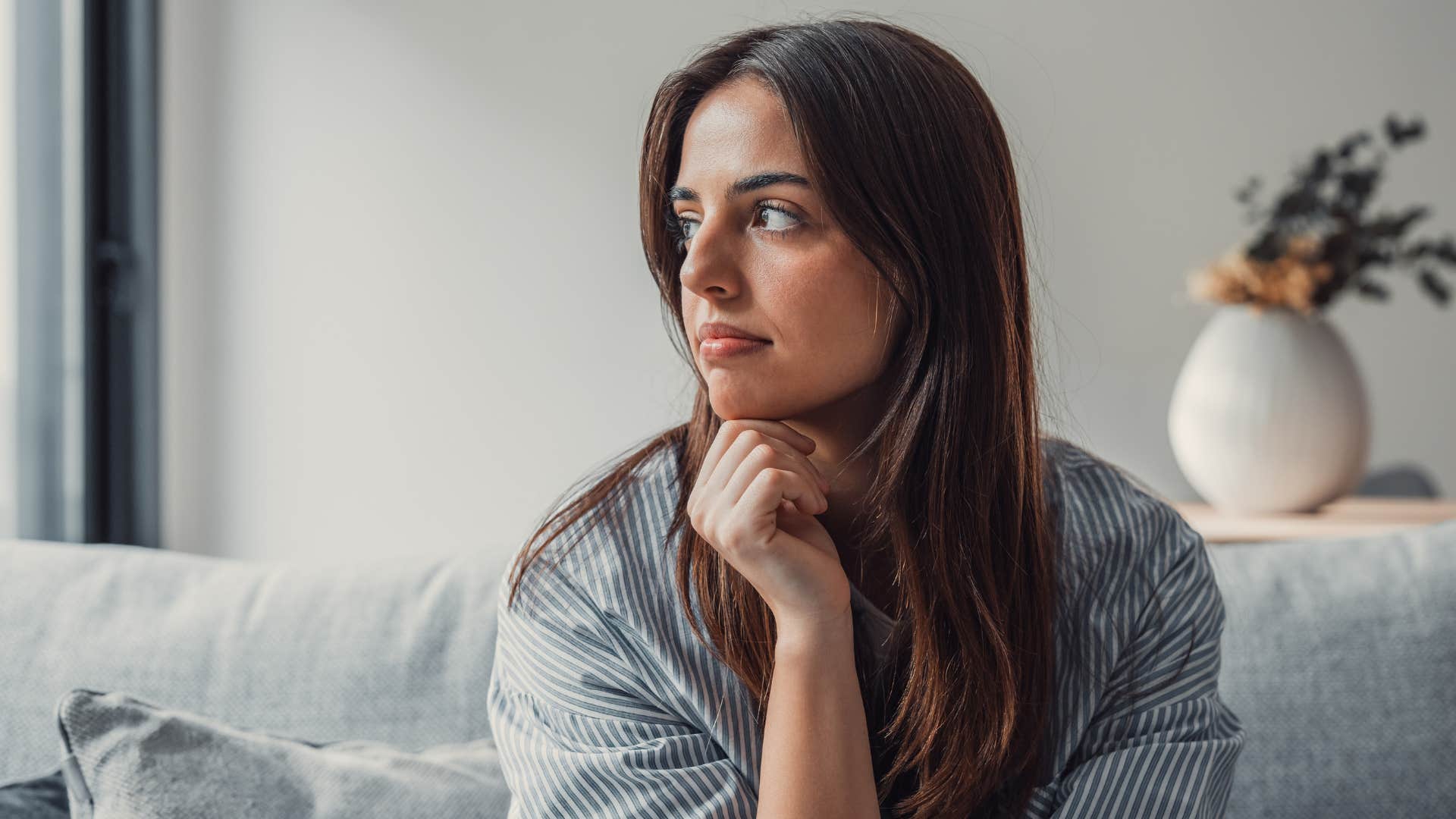 pensive woman sitting on a couch