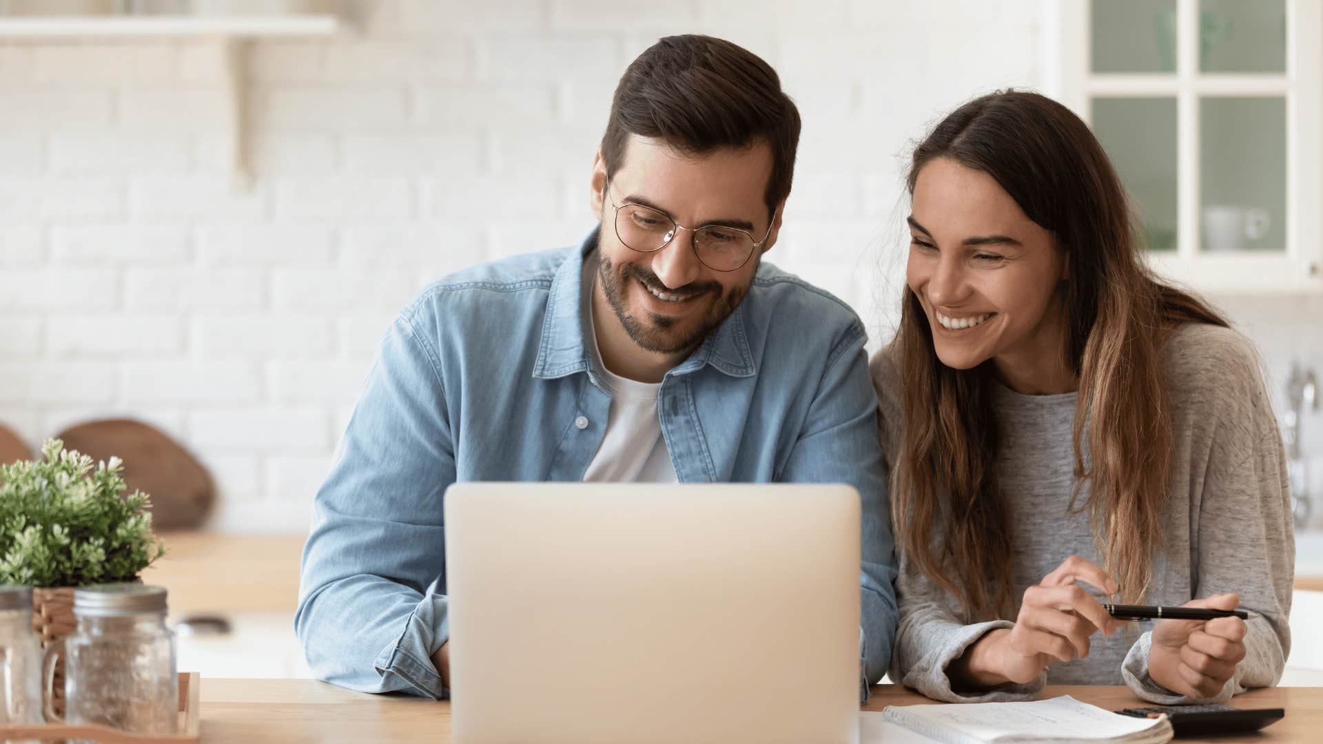 couple smiling in front of a laptop