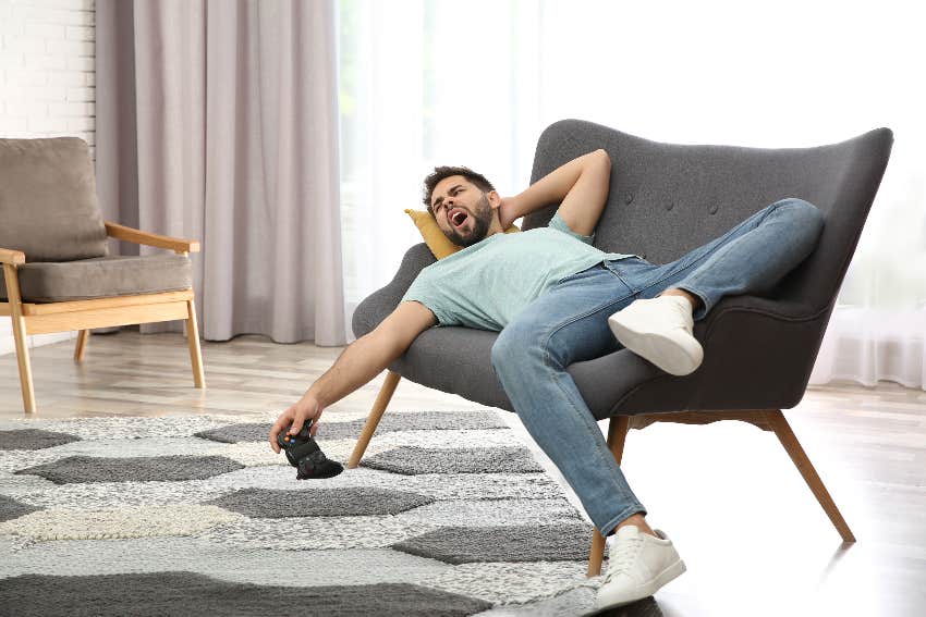 lazy man yawning and holding game controller