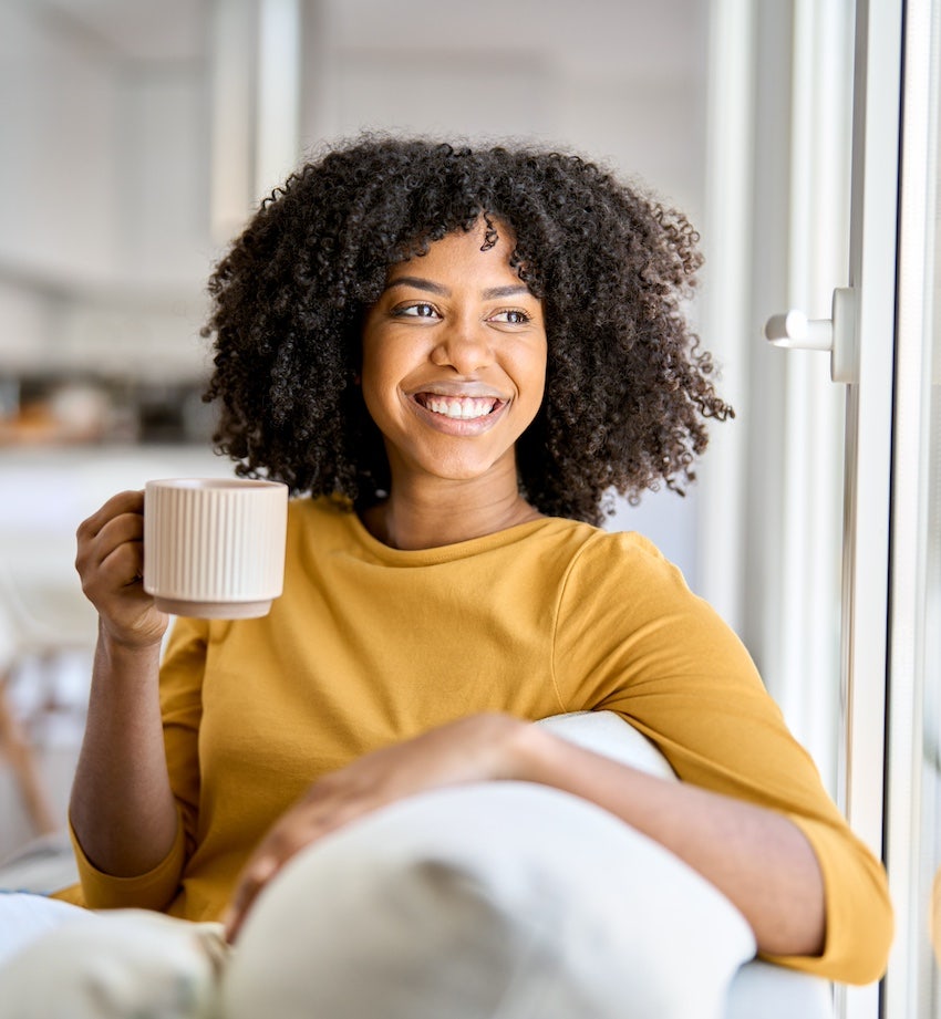 Woman smiles with coffee cup