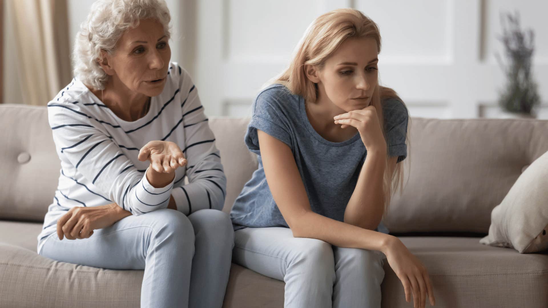 upset adult daughter sitting next to mother