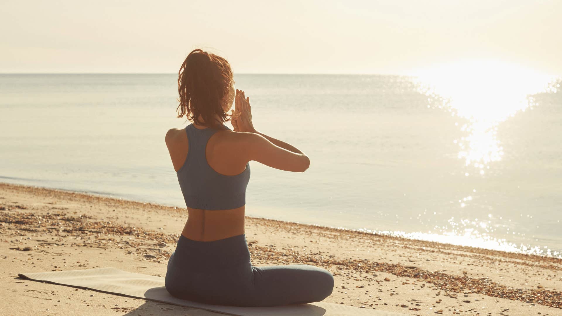 woman meditating on beach