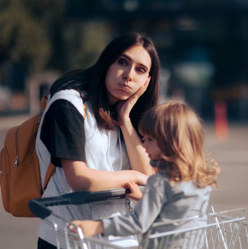 Tired parent with child in shopping cart