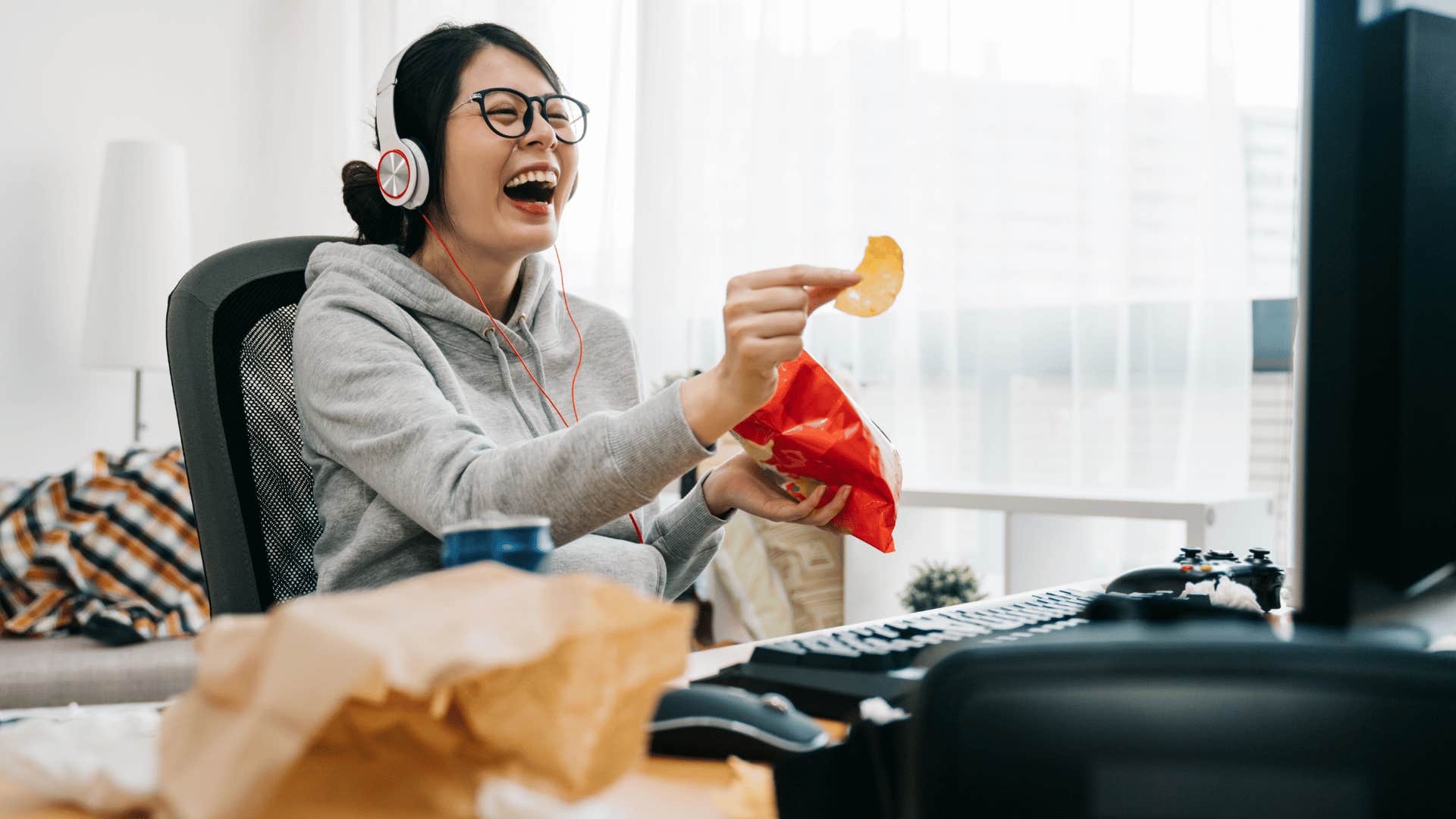 Womanin headphonesa t computer eating chips handles uncertainty well