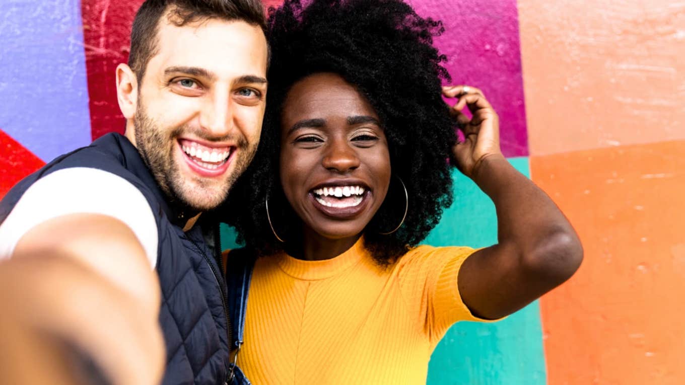 Happy couple in bright colors smiles at the camera 