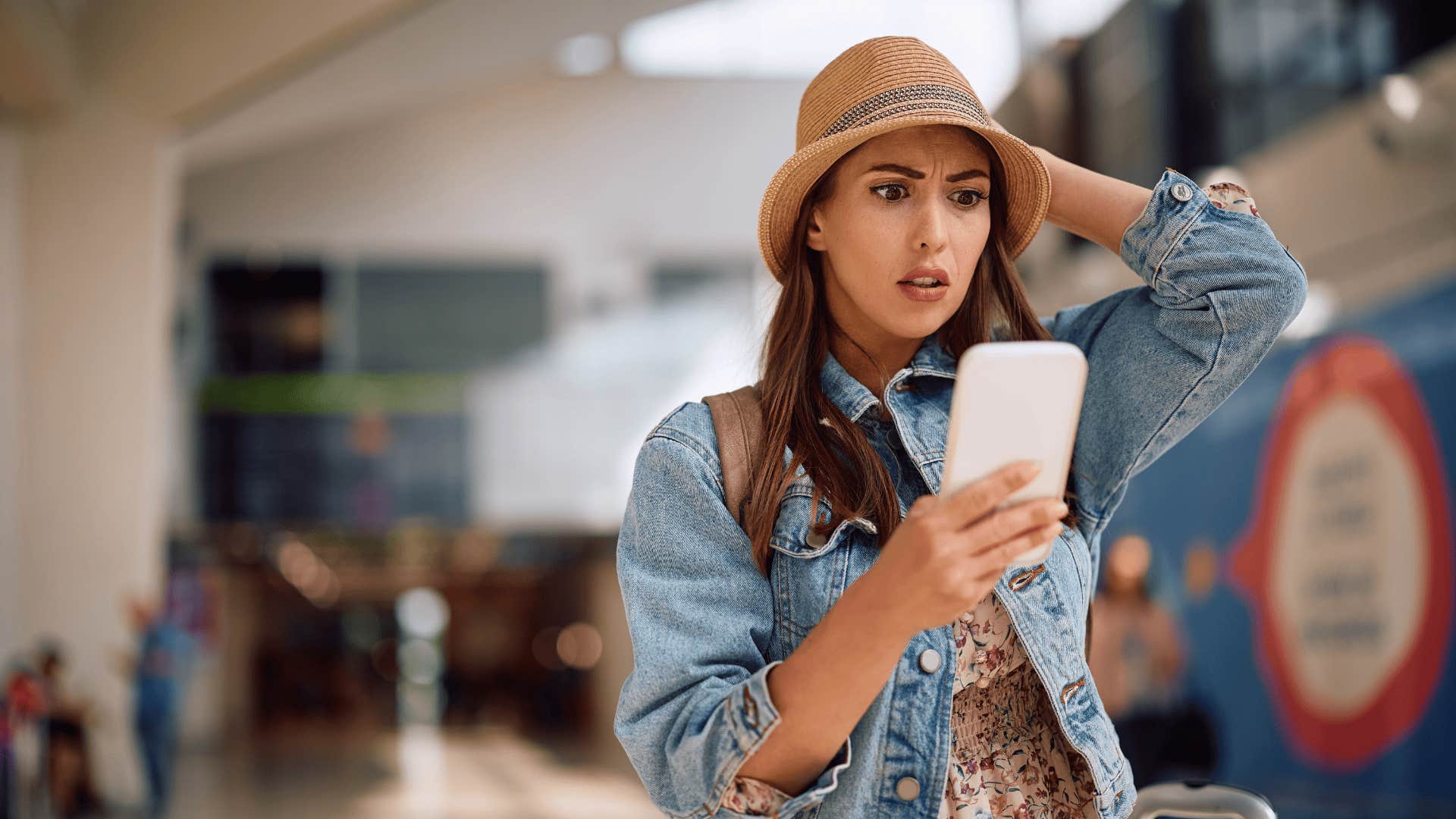 Young shocked woman using mobile phone 