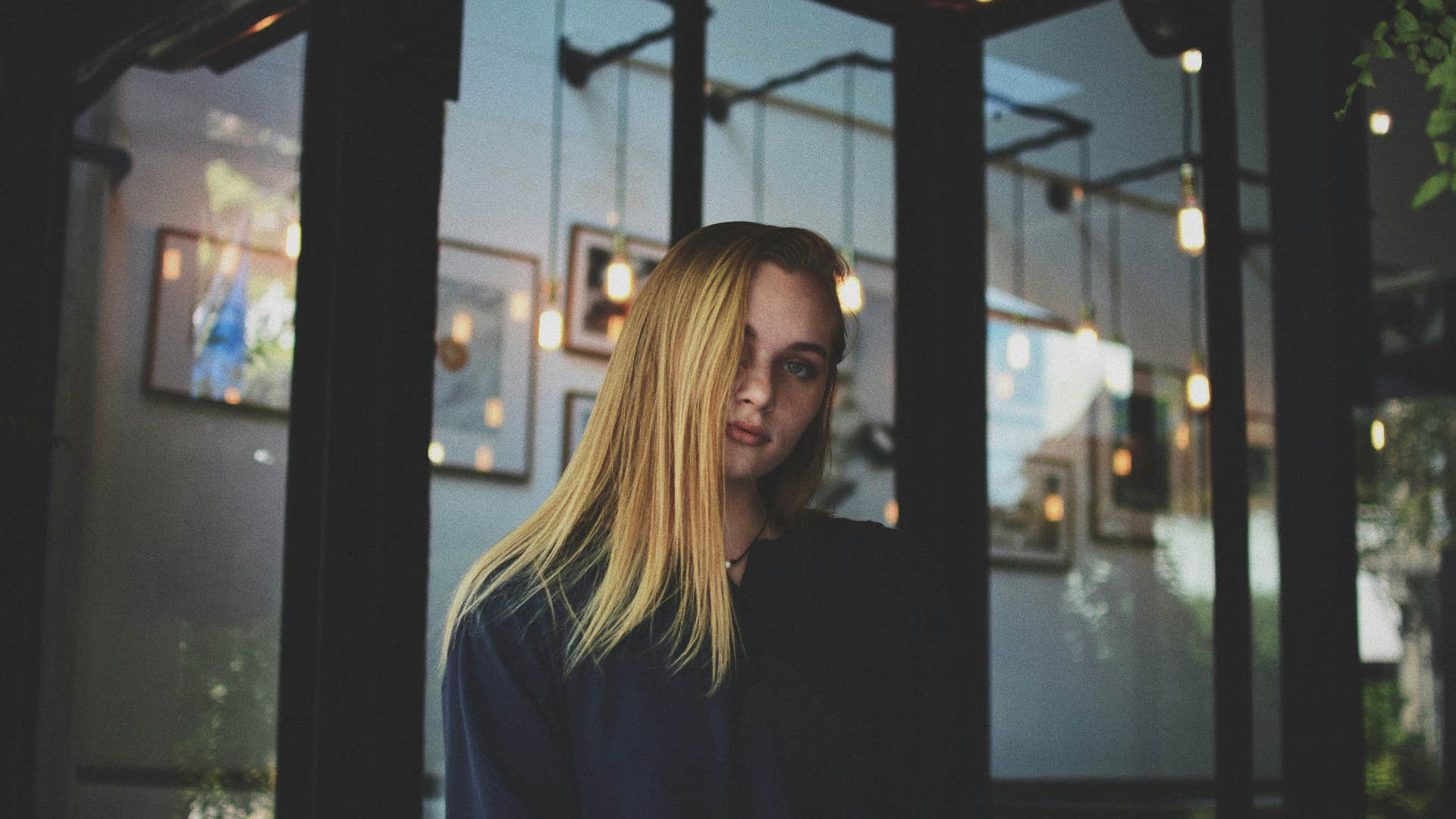 blonde woman in blue sweater looking disappointed