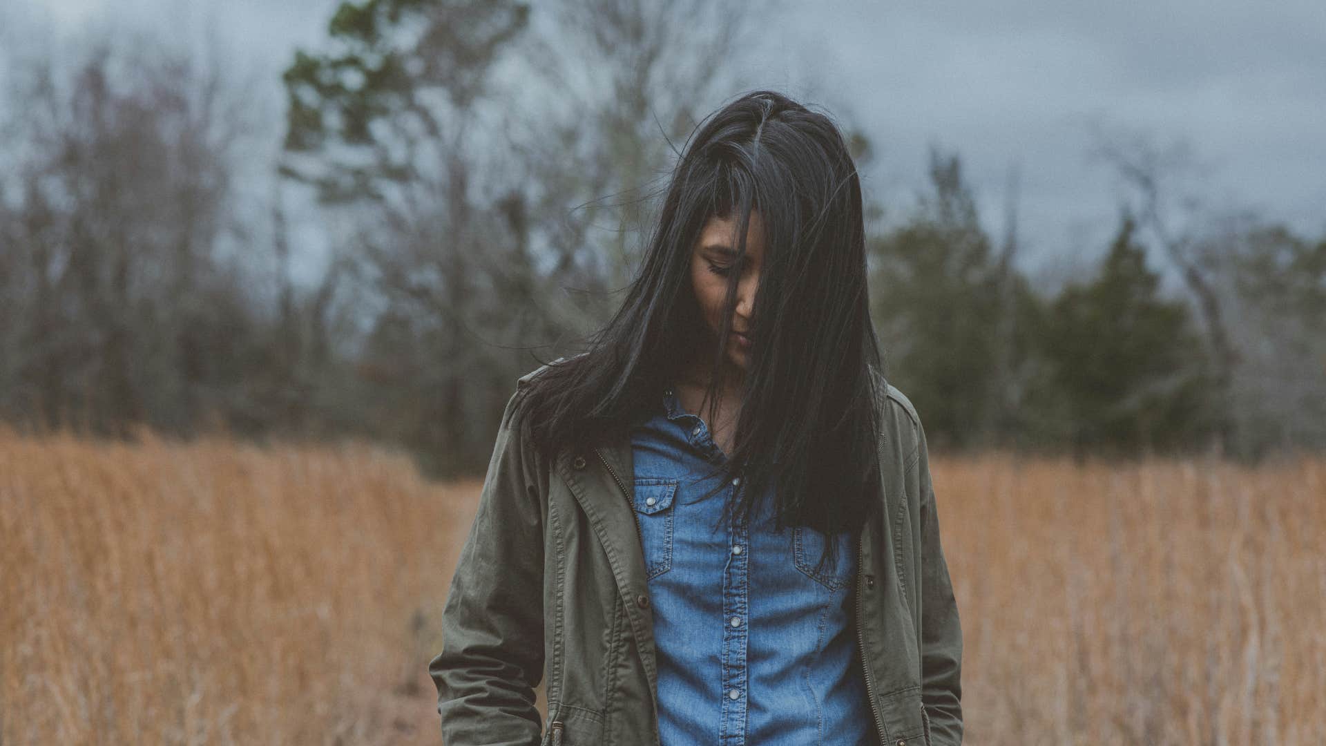 sad woman walking alone in a field