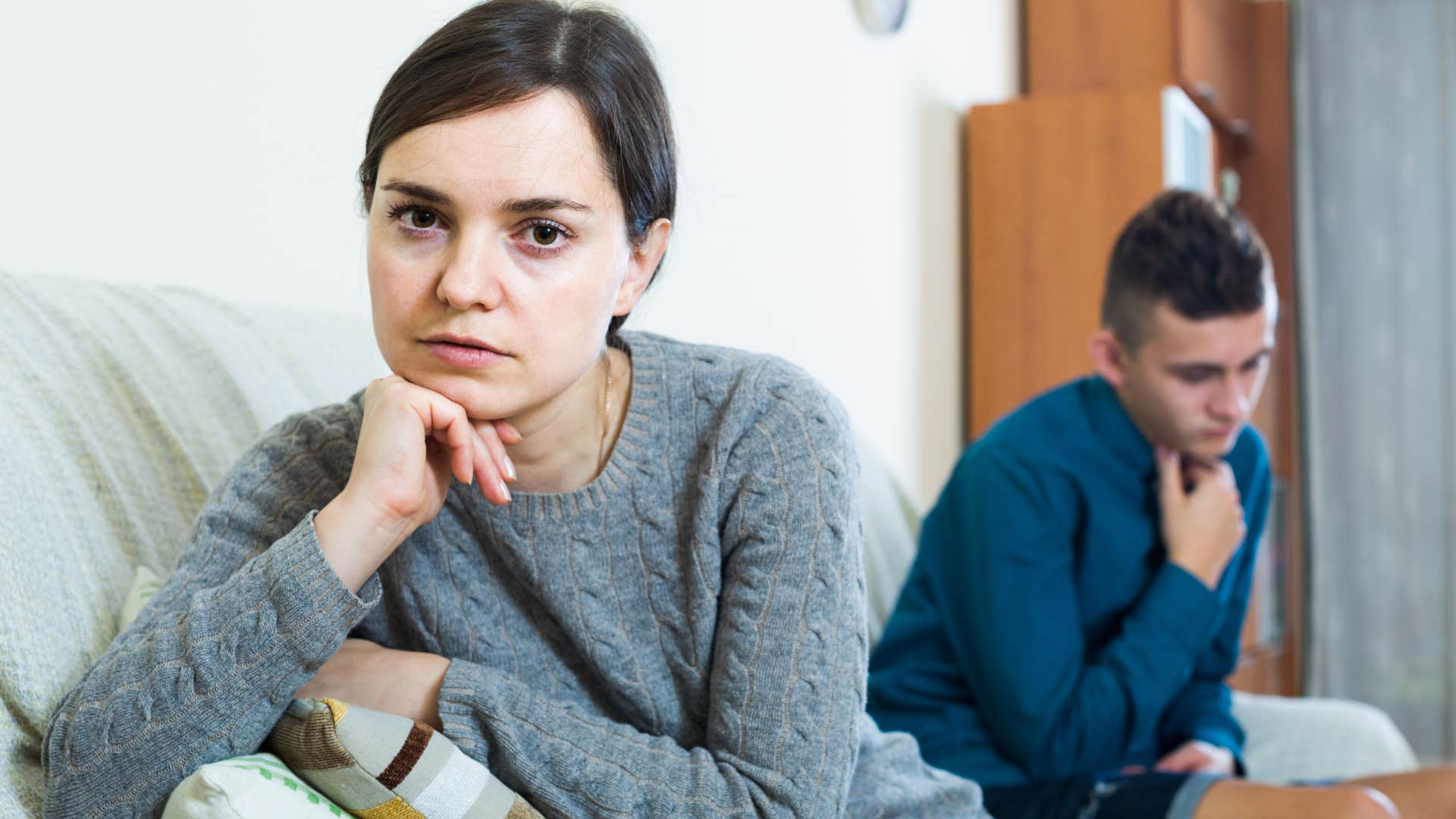 Sad mother turned away from her teenage son