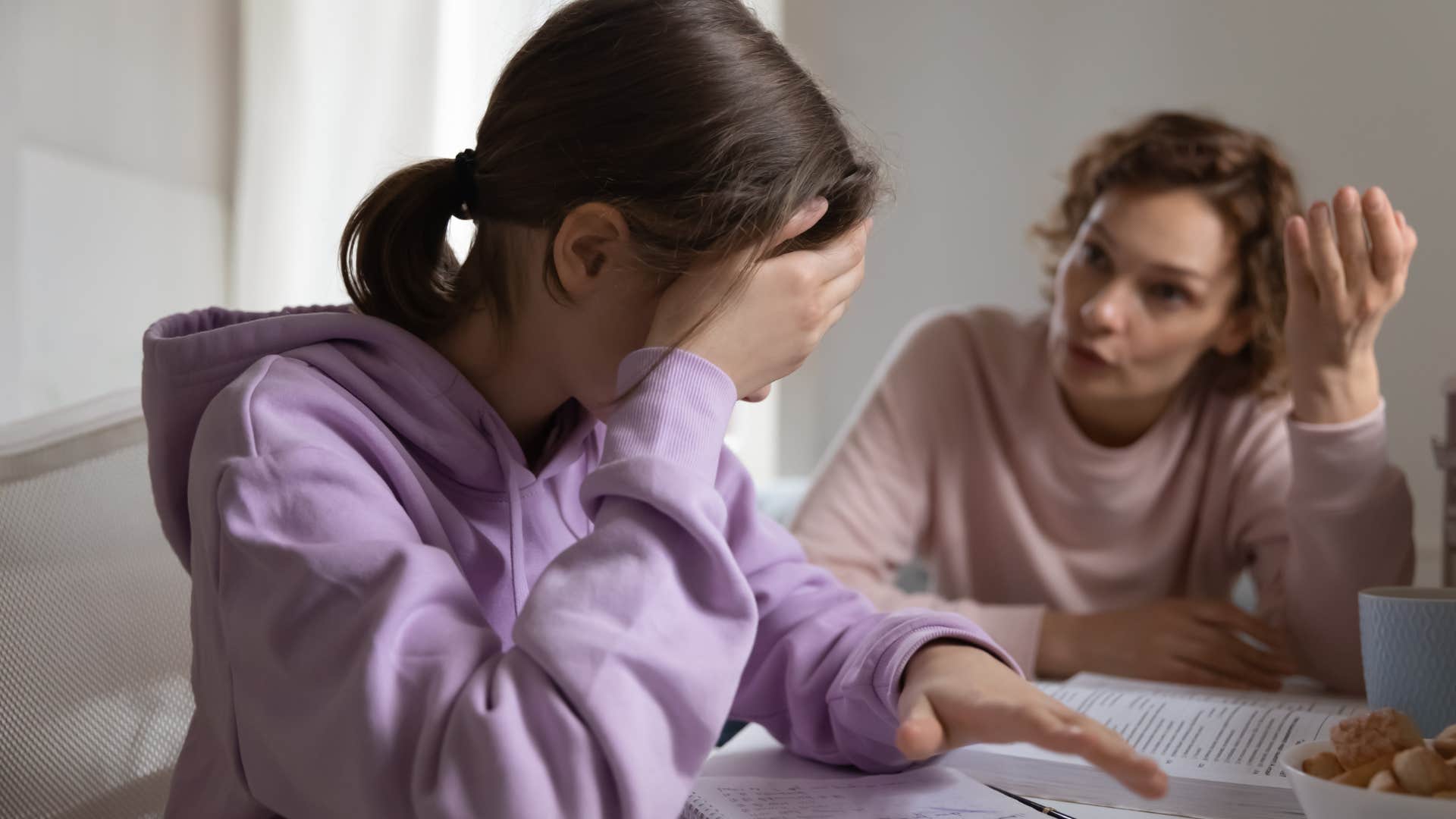 Sad teenage girl turned away from her angry mother