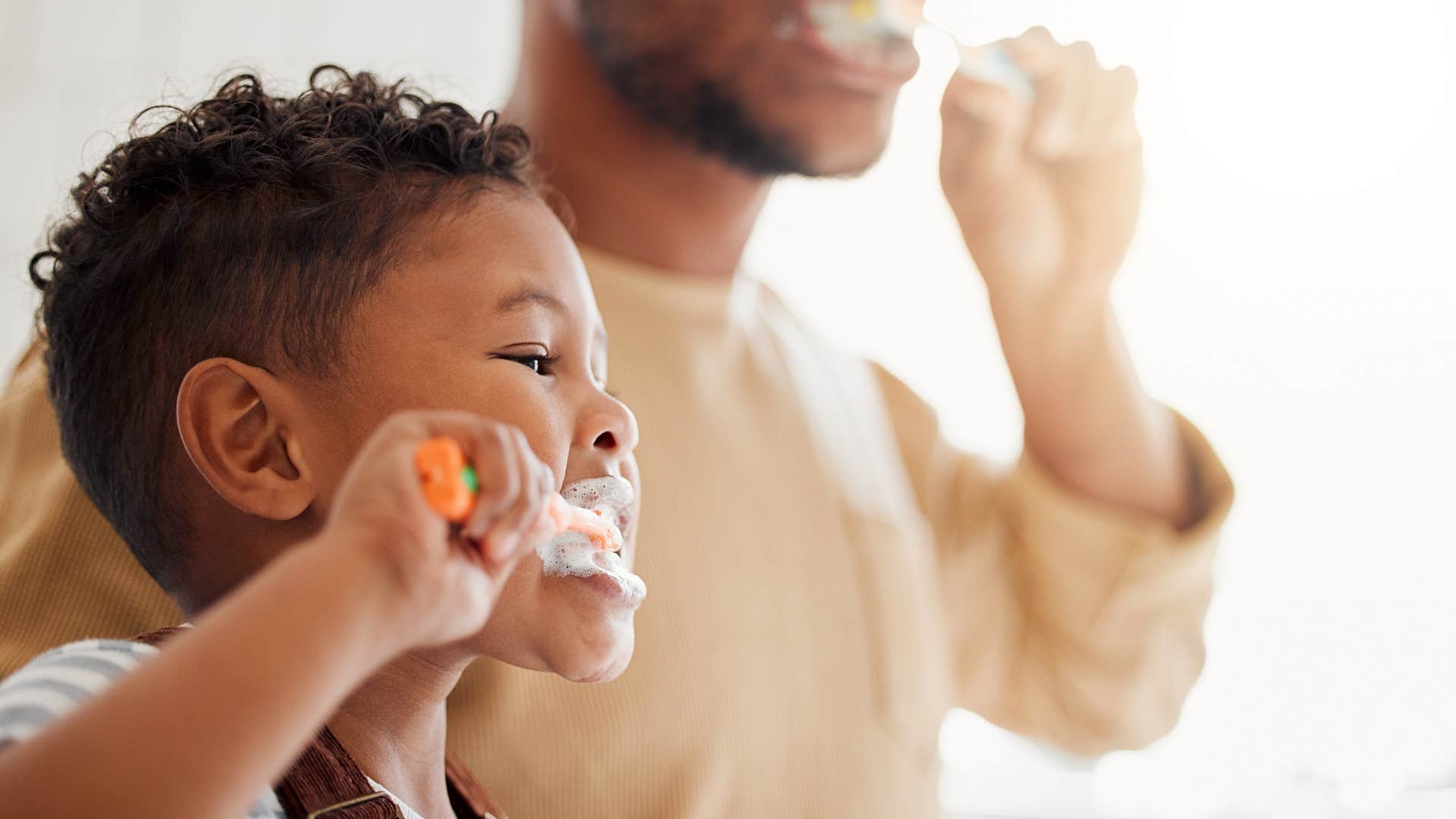 young boy brushing his teeth