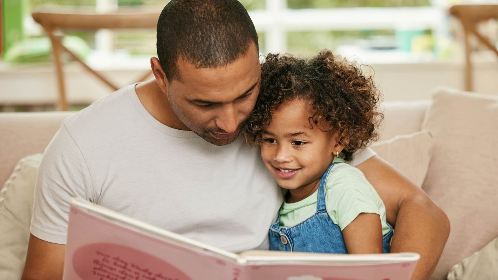 dad reading with his young daughter