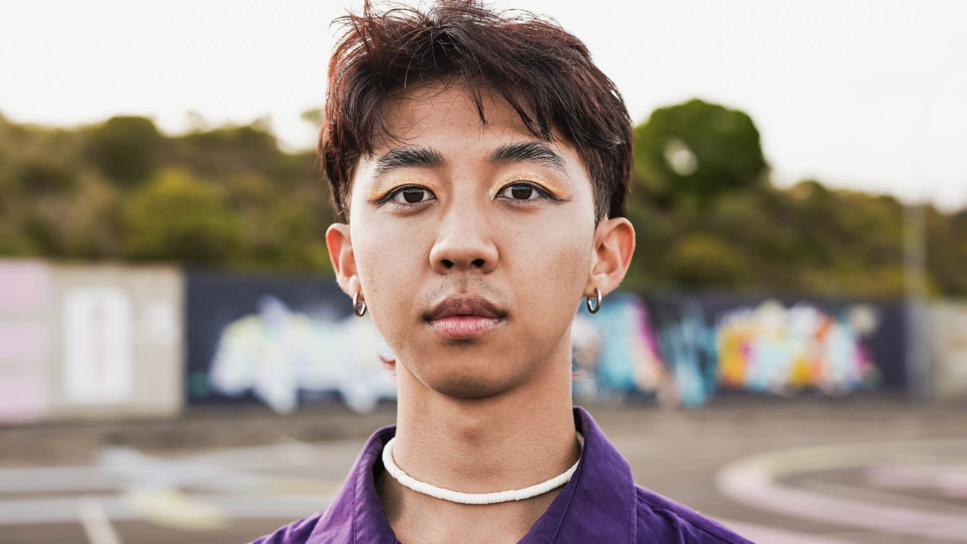 Young asian man with make up looking on camera