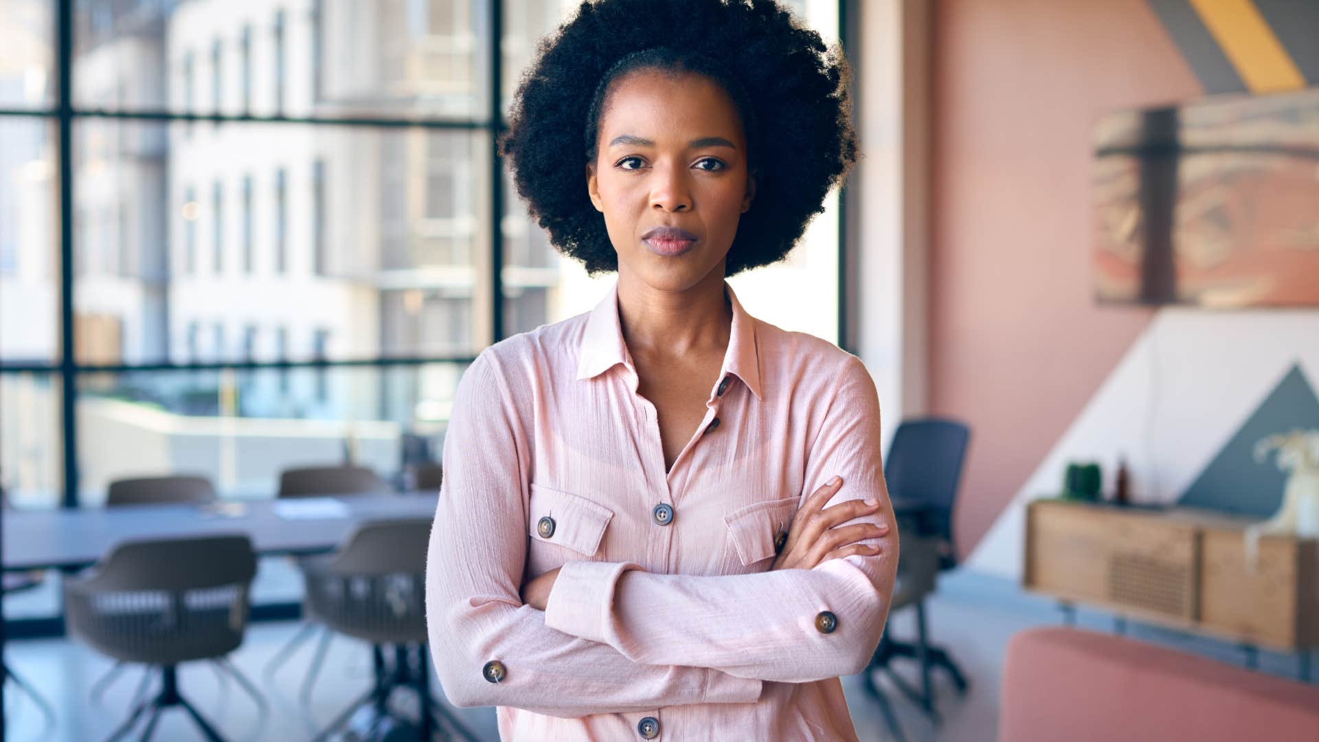 Portrait Of Businesswoman With Serious Expression Standing In Empty Office