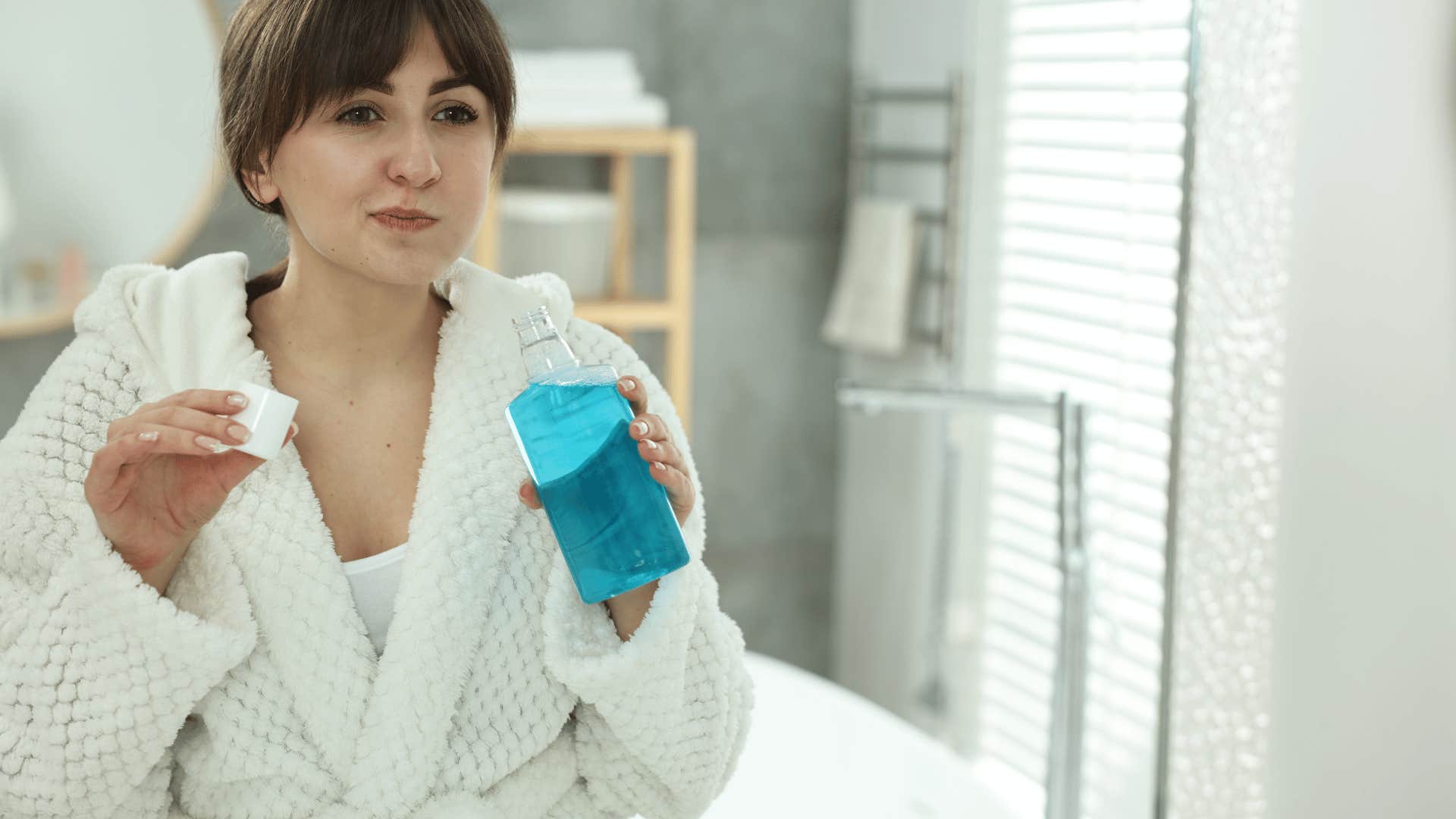 woman using mouthwash