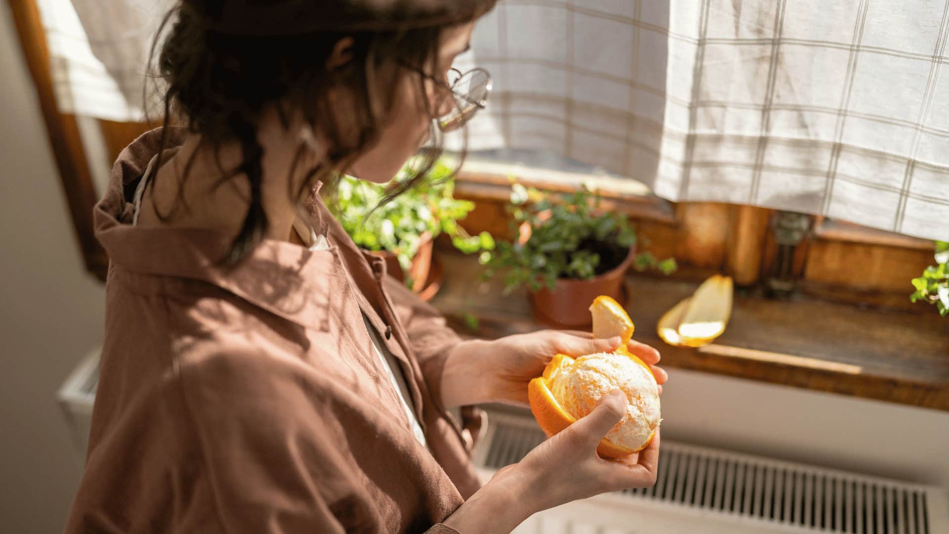 woman peeling an orange