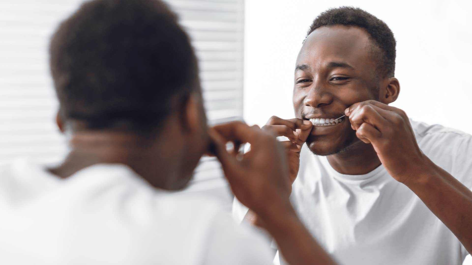 man flossing his teeth