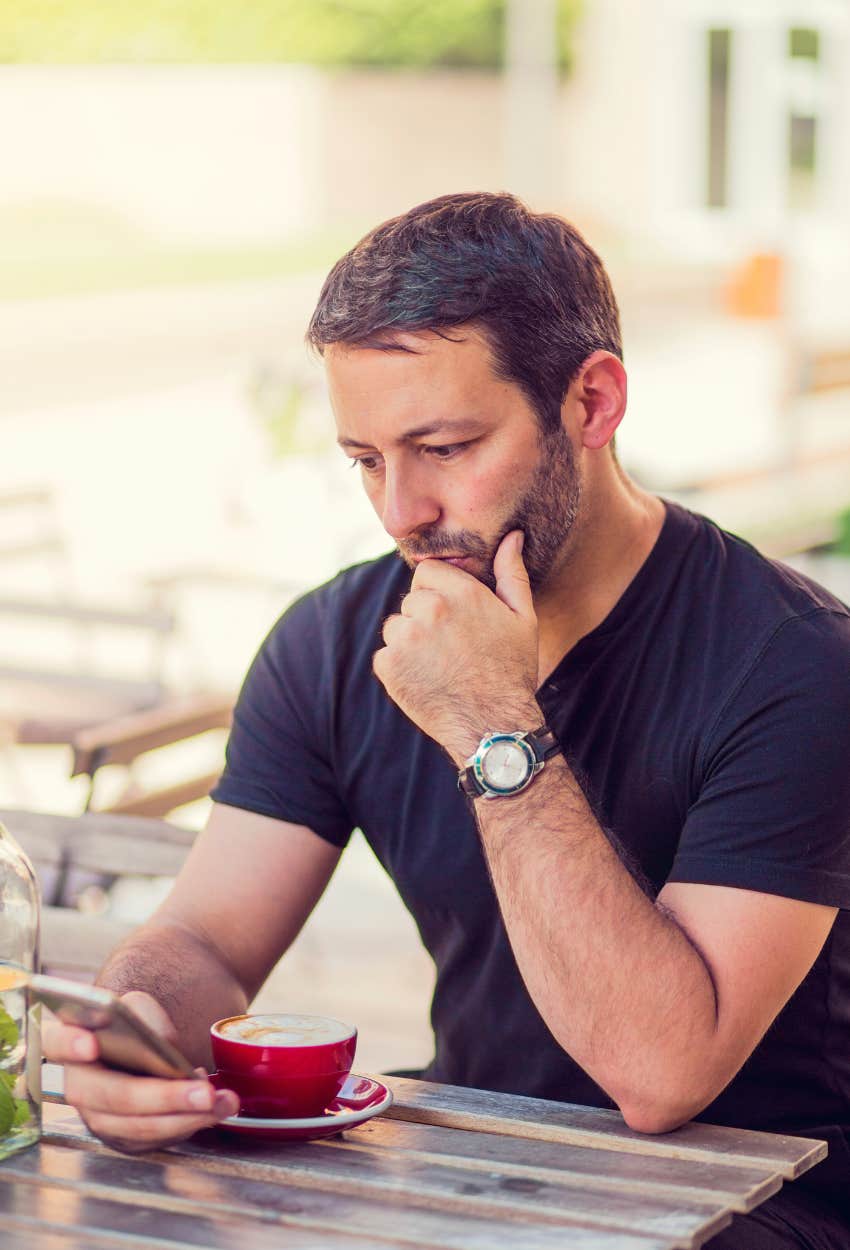 man having coffee looking at his phone