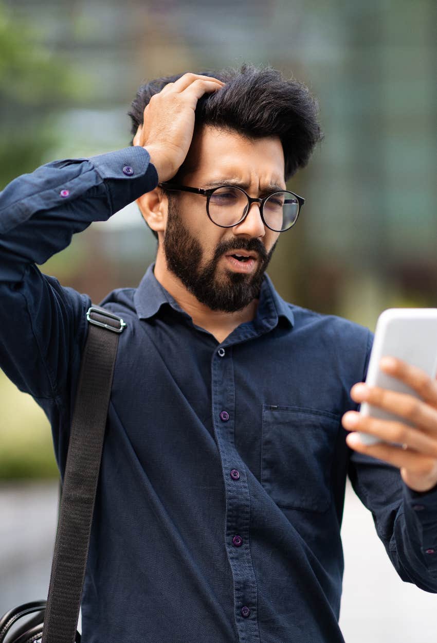 Man in a bad mood reading news self-inflicting psychological damage