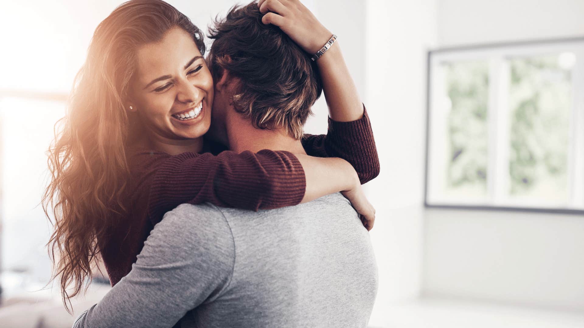 woman laughing while hugging man