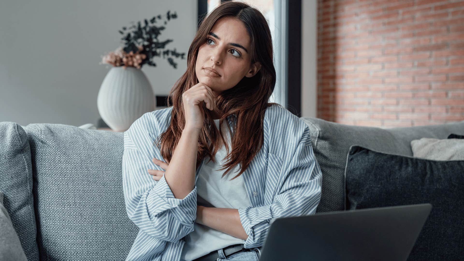 woman sitting on couch and thinking