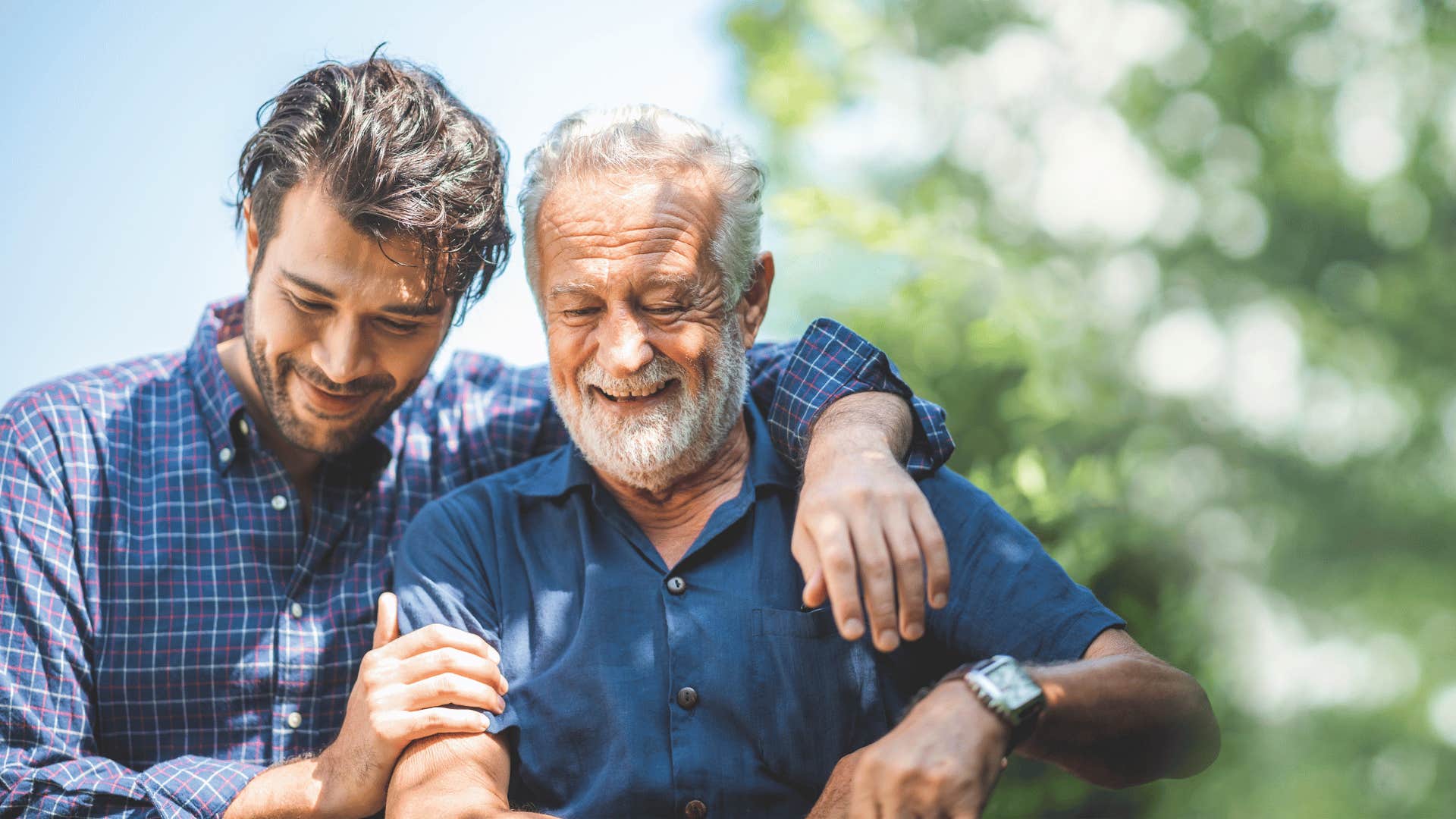 younger man with his arm around older man