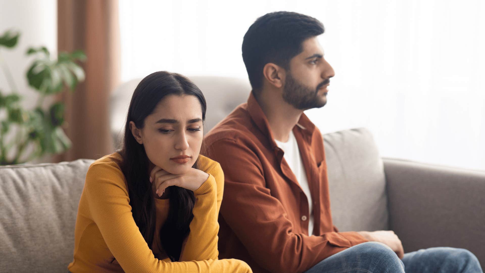 depressed wife sitting next to husband