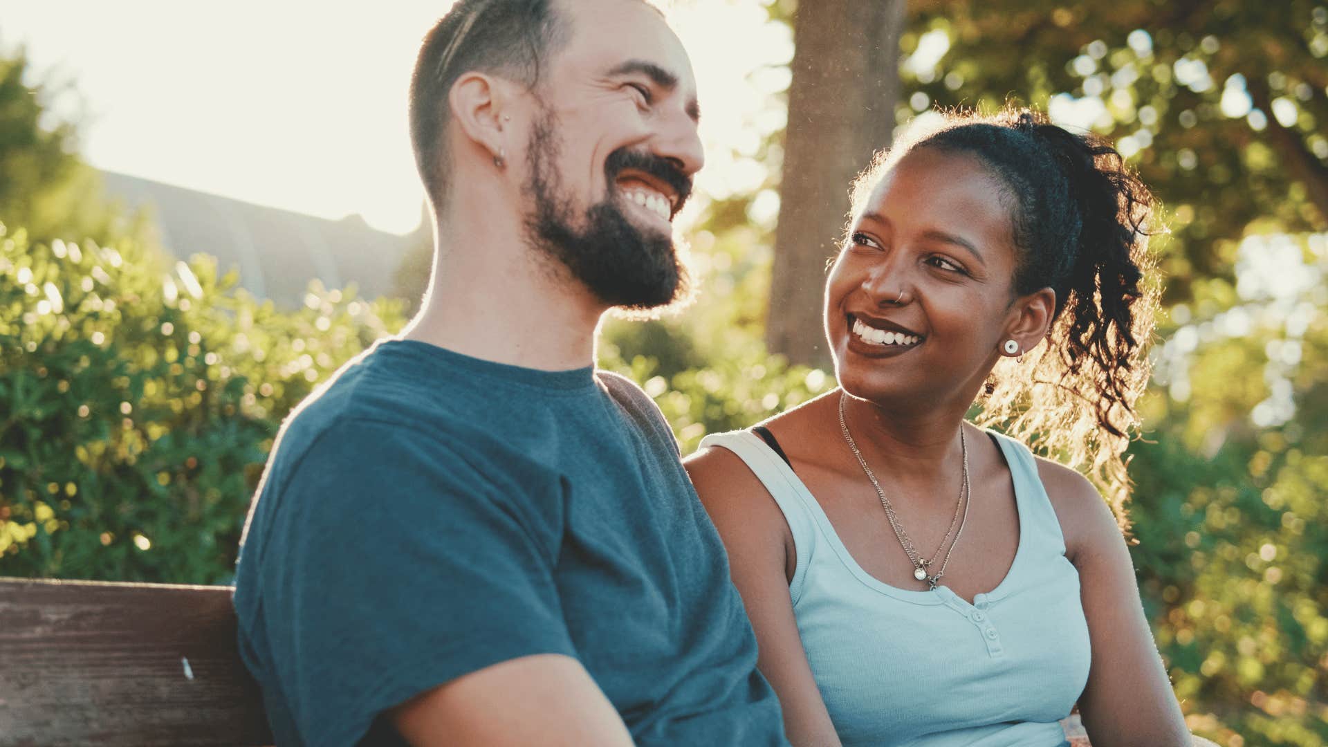 smiling couple sitting on park bench