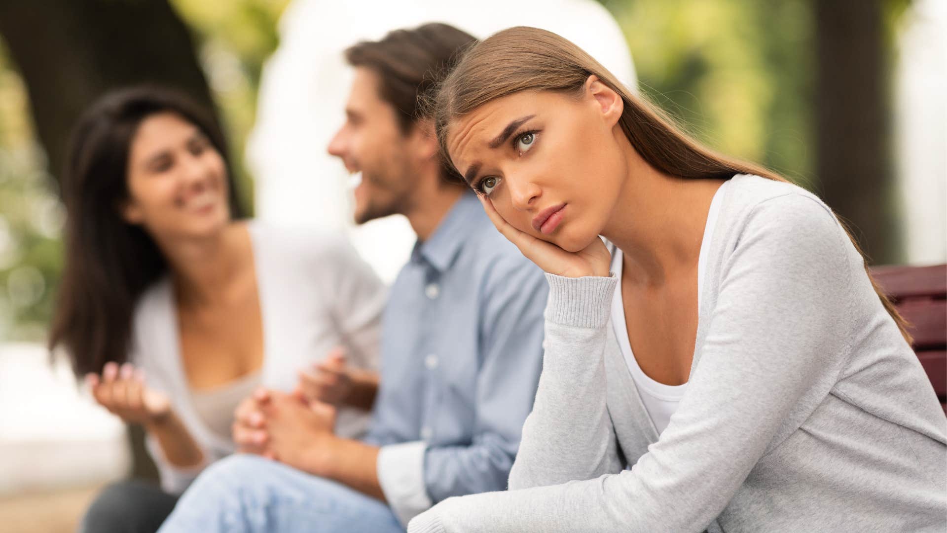 Two women, man, sad, park, bench