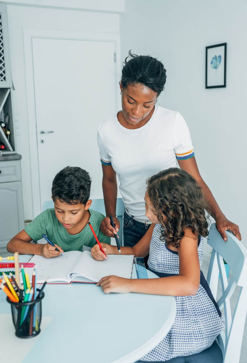 mom helping two kids with homework