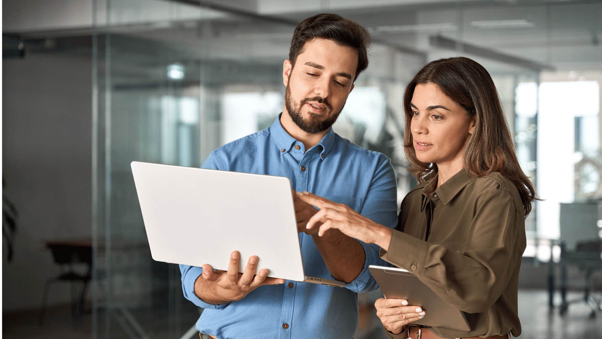 man and woman discussing what's on laptop