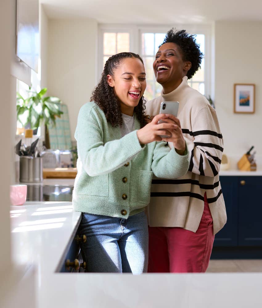 mother and daughter laughing in kitchen