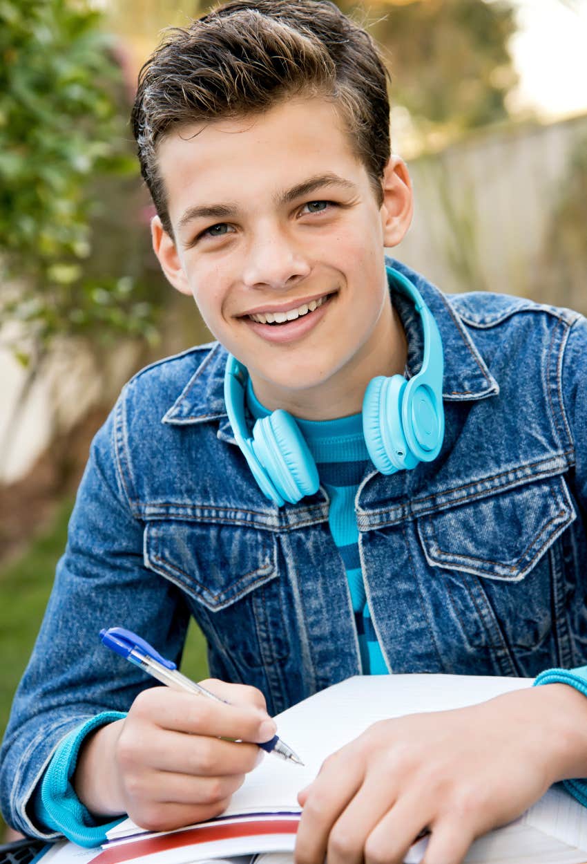 teen boy studying and smiling